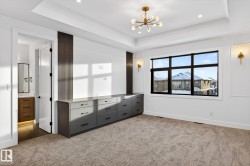 Unfurnished bedroom with a chandelier, carpet, ornamental molding, a raised ceiling, and recessed lighting - 