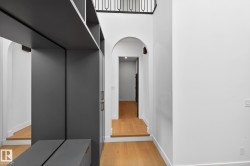 Hall with arched walkways, elevator, and light wood-style flooring - 