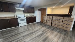 Kitchen featuring dark brown cabinets, white appliances, recessed lighting, under cabinet range hood, and light wood-style flooring - 