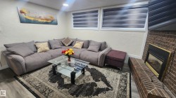 Living room featuring a textured wall, a brick fireplace, and wood finished floors - 