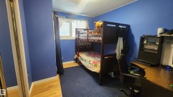 Bedroom with a textured ceiling, light wood-type flooring, and a desk - 