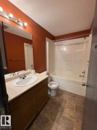 Bathroom featuring vanity, tub / shower combination, and a textured ceiling - 