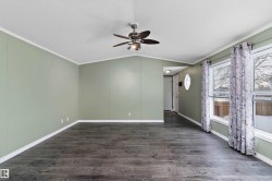 Empty room featuring crown molding, dark wood-type flooring, a textured ceiling, vaulted ceiling, and ceiling fan - 