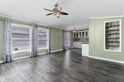 Unfurnished living room with crown molding, a textured ceiling, vaulted ceiling, dark wood-style flooring, and ceiling fan - 