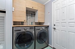 Laundry area with independent washer and dryer, a heating unit, a textured ceiling, and cabinet space - 