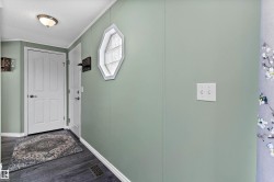 Doorway with wood finished floors and crown molding - 