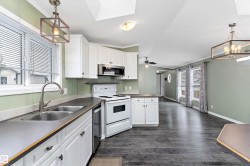 Kitchen featuring decorative light fixtures, a chandelier, ornamental molding, stainless steel appliances, and white cabinetry - 