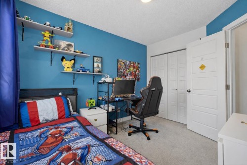 This room features a vibrant blue accent wall, neutral carpeting, and white trim - 8 Daniel Street, Fort Saskatchewan, AB - Indoor