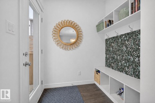 Entryway featuring built-in shelving with storage cubbies, coat hooks, and a decorative mirror - 8 Daniel Street, Fort Saskatchewan, AB - Indoor Photo Showing Other Room