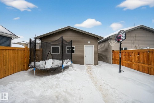 The property features a detached garage with horizontal siding and a white door, situated within a fenced yard - 8 Daniel Street, Fort Saskatchewan, AB - Outdoor
