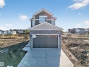 View of front facade featuring a residential view, stone siding, and driveway - 3285 Chernowski Way Sw, Edmonton, AB  - Outdoor 