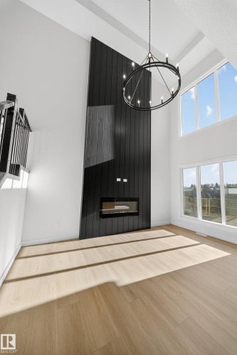 Unfurnished dining area with wood finished floors and a towering ceiling - 3285 Chernowski Way Sw, Edmonton, AB - Indoor Photo Showing Other Room