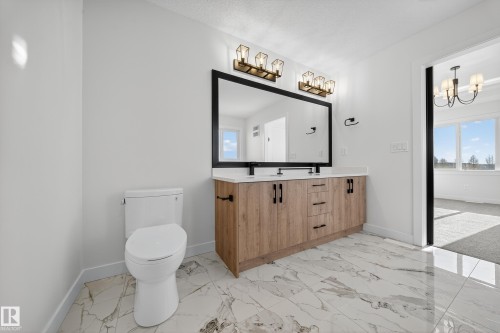 Bathroom with light marble finish floors, double vanity, and a chandelier - 3285 Chernowski Way Sw, Edmonton, AB - Indoor Photo Showing Bathroom