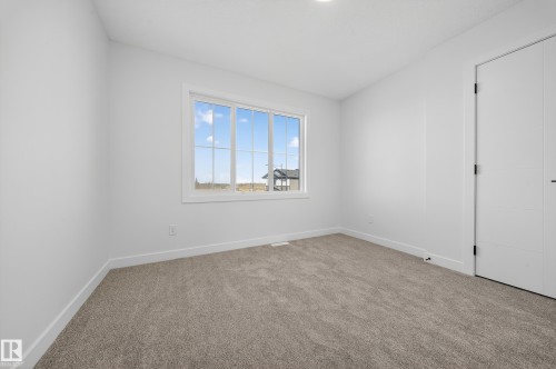 Unfurnished room featuring light colored carpet and baseboards - 3285 Chernowski Way Sw, Edmonton, AB - Indoor Photo Showing Other Room