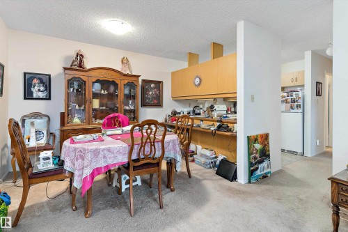 Dining area featuring a textured ceiling and light colored carpet - 305 32 Alpine Place, St. Albert, AB - Indoor Photo Showing Dining Room