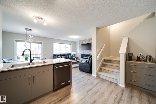 9040 Cooper Link, Edmonton, AB - Indoor Photo Showing Kitchen With Fireplace With Double Sink