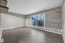 Spare room with a baseboard radiator, dark wood-type flooring, a textured ceiling, and an accent wall - 