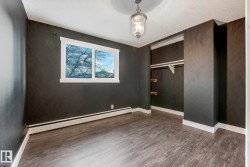 Unfurnished bedroom featuring baseboard heating, dark wood finished floors, and a closet - 