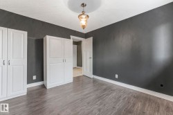 Unfurnished bedroom with wood finished floors and baseboards - 