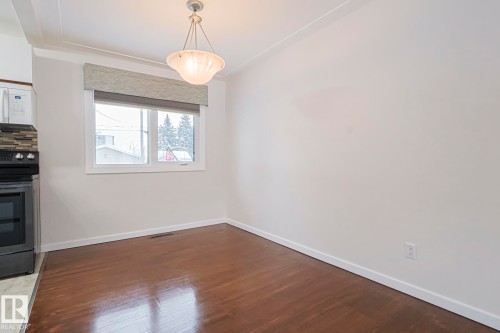 Unfurnished dining area with dark wood-style floors and baseboards - 13419 102 Street, Edmonton, AB - Indoor Photo Showing Other Room
