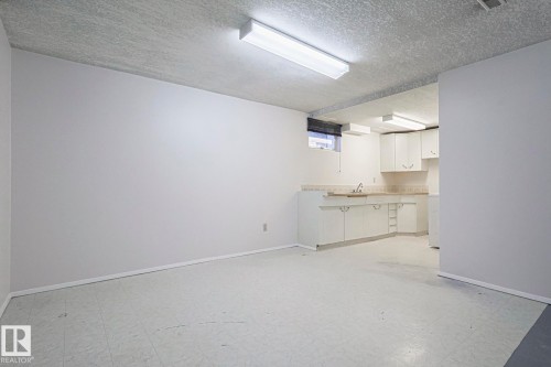Below grade area with light flooring and a textured ceiling - 13419 102 Street, Edmonton, AB - Indoor