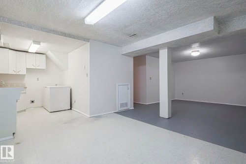 Finished below grade area featuring tile patterned floors and a textured ceiling - 13419 102 Street, Edmonton, AB - Indoor