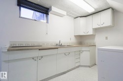 Kitchen with light floors, white cabinets, and light countertops - 