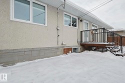View of snow covered exterior with stucco siding and a deck - 