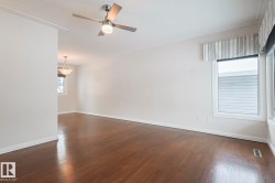 Empty room featuring dark wood-style flooring and ceiling fan - 