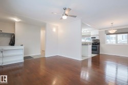 Unfurnished living room featuring dark wood-type flooring and ceiling fan - 