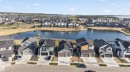 Modern residential development showcasing a row of distinct single-family homes, each with a double garage and concrete driveway - 27 Rosewood Way, St. Albert, AB  - Outdoor With Body Of Water With Facade 
