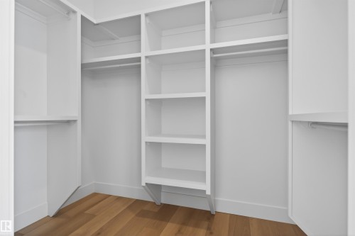 This custom closet features extensive white shelving and hanging rods, providing ample storage - 27 Rosewood Way, St. Albert, AB - Indoor With Storage