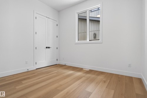 This room features light-toned hardwood flooring, white walls, and a window with white trim - 27 Rosewood Way, St. Albert, AB - Indoor Photo Showing Other Room