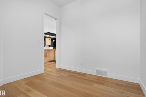This room features light-toned hardwood flooring and white walls with white baseboards - 27 Rosewood Way, St. Albert, AB - Indoor Photo Showing Other Room