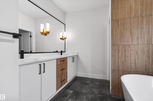Bathroom vanity featuring dual sinks with matte black fixtures, integrated storage, and a full-width mirror - 27 Redpoll Wynd, St. Albert, AB - Indoor Photo Showing Bathroom