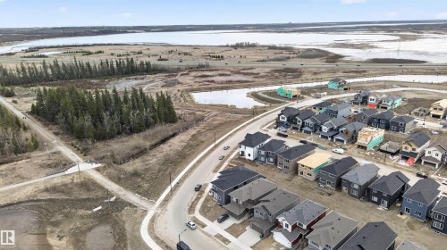New construction residences featuring varied exterior finishes and attached garages - 27 Redpoll Wynd, St. Albert, AB - Outdoor With Body Of Water With View