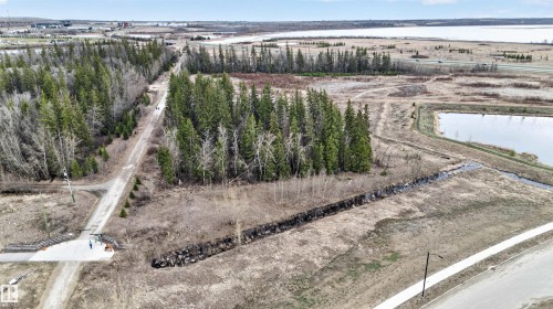 Expansive natural landscape featuring evergreen forests, undeveloped land, a distant body of water, and a paved pathway - 27 Redpoll Wynd, St. Albert, AB - Outdoor With View