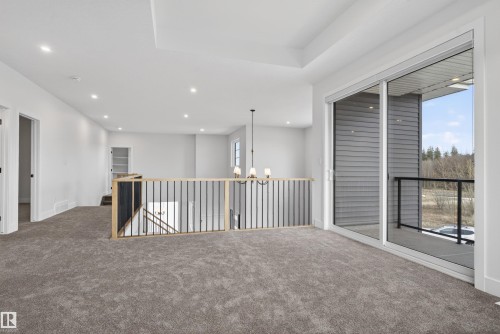 Expansive carpeted loft space featuring a tray ceiling with recessed lighting - 27 Redpoll Wynd, St. Albert, AB - Indoor Photo Showing Other Room