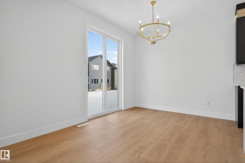 Unfurnished dining area featuring a chandelier and light wood-style floors - 19 Rosa Crescent, St. Albert, AB - Indoor Photo Showing Other Room With Fireplace