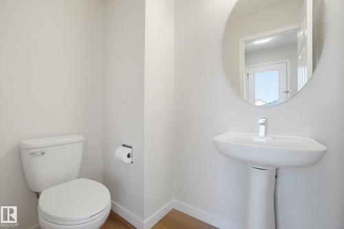 Half bathroom featuring toilet and wood finished floors - 3014 31 Avenue, Edmonton, AB - Indoor Photo Showing Bathroom