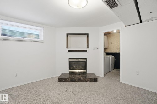 Basement with a glass covered fireplace and light carpet - 3014 31 Avenue, Edmonton, AB - Indoor With Fireplace