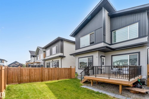 Back of house featuring a fenced backyard, a wooden deck, and board and batten siding - 15518 13A Avenue, Edmonton, AB - Outdoor With Deck Patio Veranda