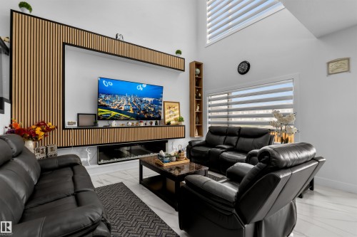 Living area featuring a high ceiling, marble look tiles, and built in features - 15518 13A Avenue, Edmonton, AB - Indoor Photo Showing Living Room