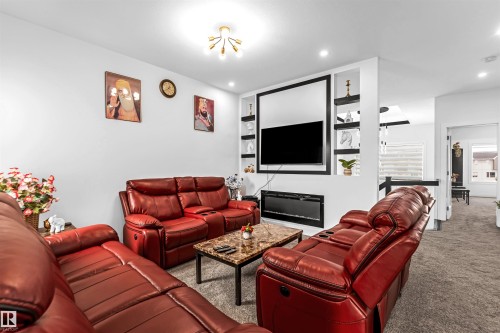 Living area with carpet floors, built in shelves, and recessed lighting - 15518 13A Avenue, Edmonton, AB - Indoor Photo Showing Living Room With Fireplace