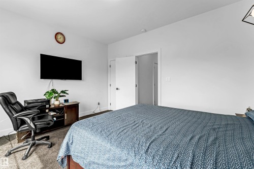 Carpeted bedroom featuring a desk and baseboards - 15518 13A Avenue, Edmonton, AB - Indoor Photo Showing Bedroom