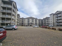View of apartment building / complex featuring uncovered parking - 