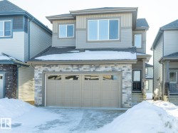 View of front of house with stone siding and a garage - 