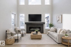 Living area with a glass covered fireplace, a towering ceiling, and healthy amount of natural light - 