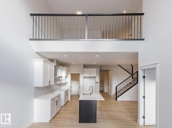 Kitchen featuring white cabinetry, a center island with sink, light wood-style flooring, light stone counters, and recessed lighting - 
