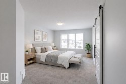 Bedroom featuring a barn door and light colored carpet - 
